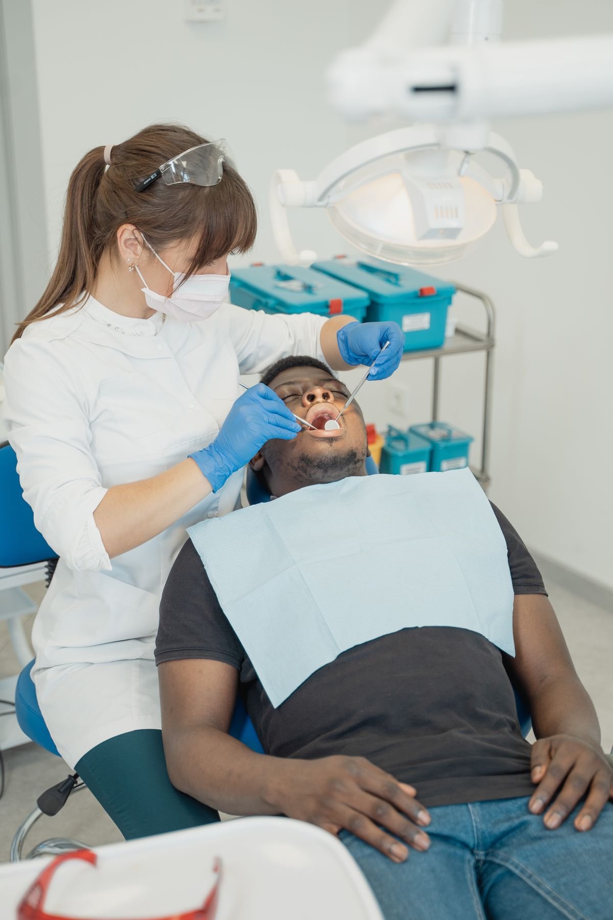 Dentista atendiendo con calma a un paciente recostado en el sillón dental durante una consulta de urgencia.