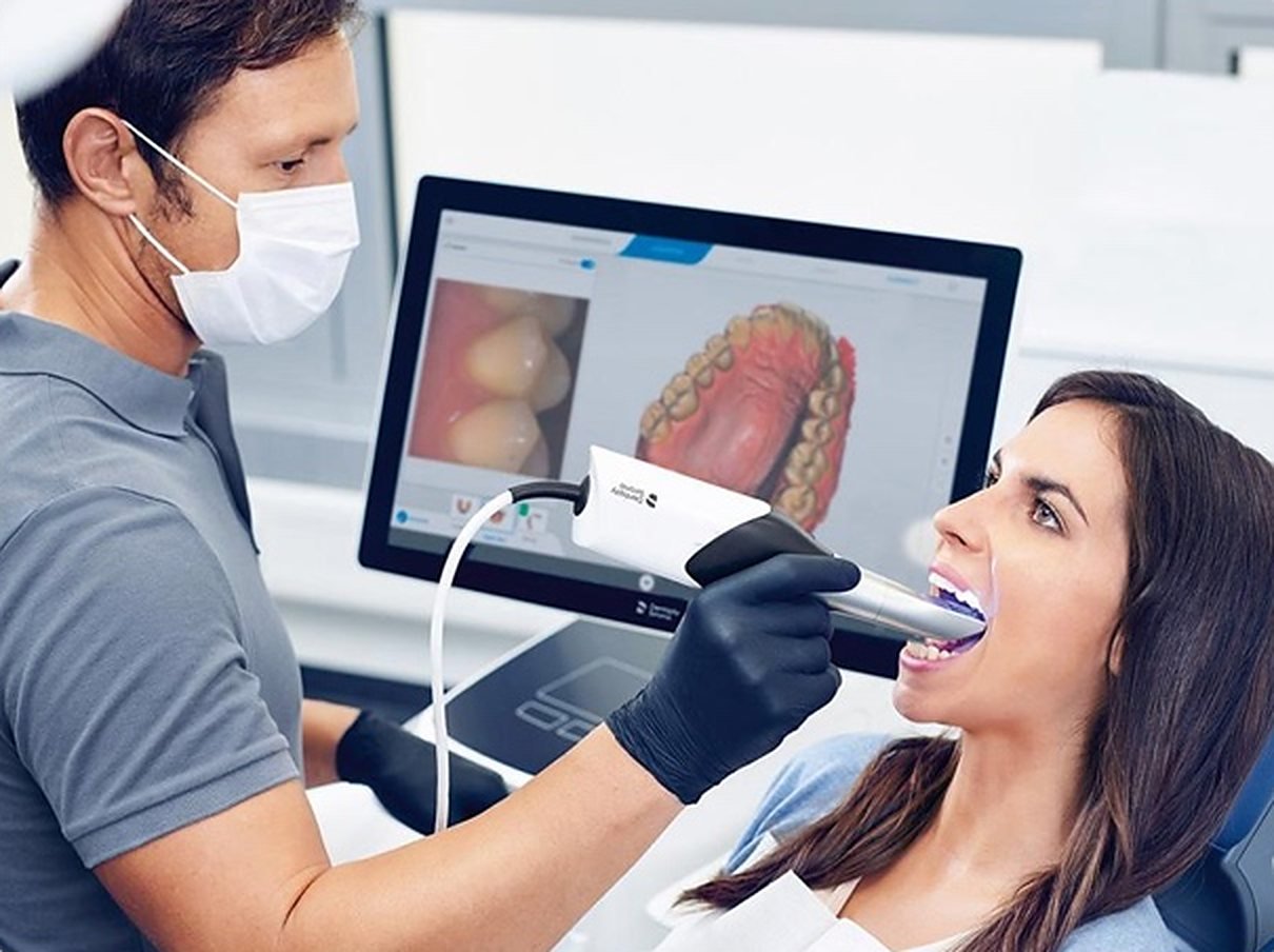 Dentista realizando un escaneo intraoral digital a una paciente.
